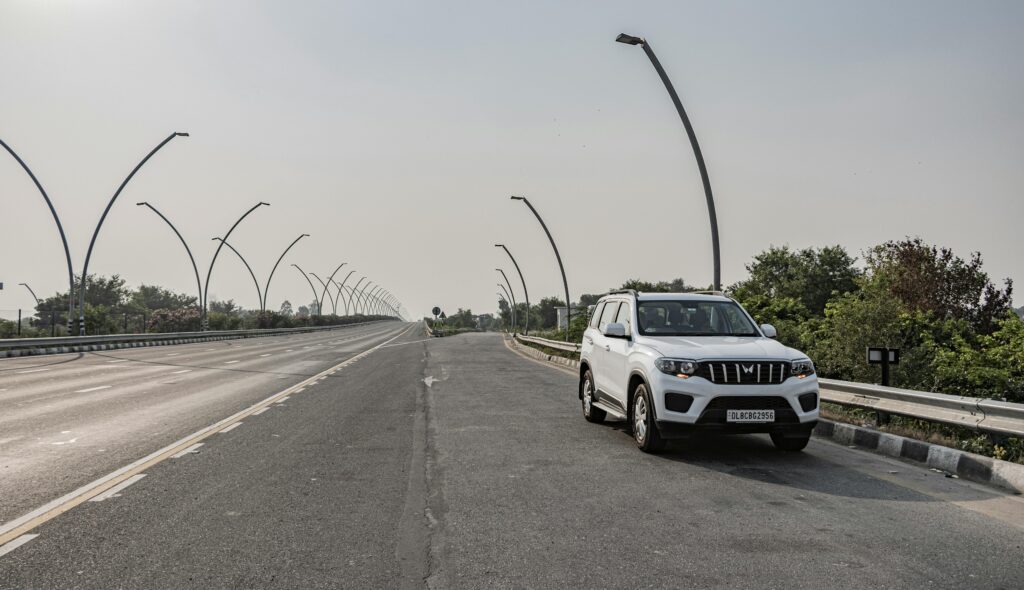 pexels photo 29057959 29057959 A white SUV parked on an expressway near Deeg, Uttar Pradesh, India under clear skies.