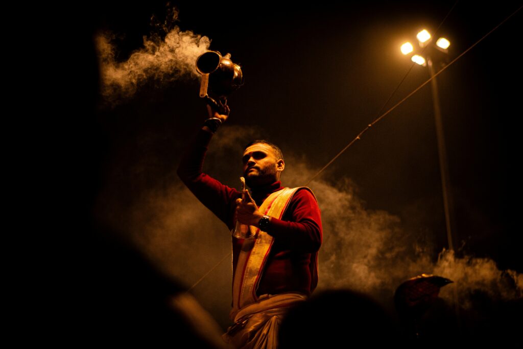 Delhi to Haridwar Tour A Hindu priest performs a traditional Ganga Aarti ceremony on the ghats of Varanasi at night.
